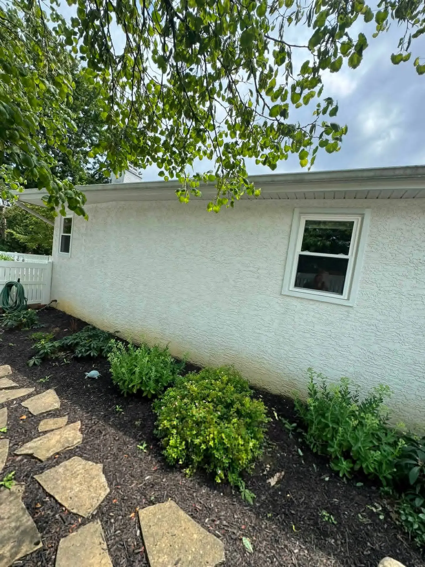 Exterior side wall and garden of a renovated stucco home